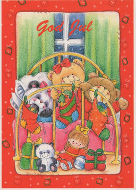 Christmas card with teddy bears and a child in a crib, featuring the text 'God Jul' on a red border.