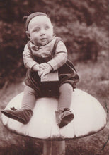 Load image into Gallery viewer, Vintage black and white photo of a child sitting on a mushroom-shaped object outdoors.
