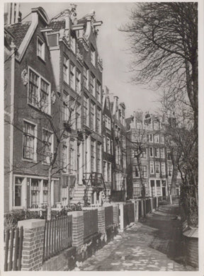 Narrow street with row houses on either side in a black and white photograph