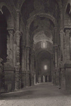 Load image into Gallery viewer, Dark interior of a stone building with arches and columns
