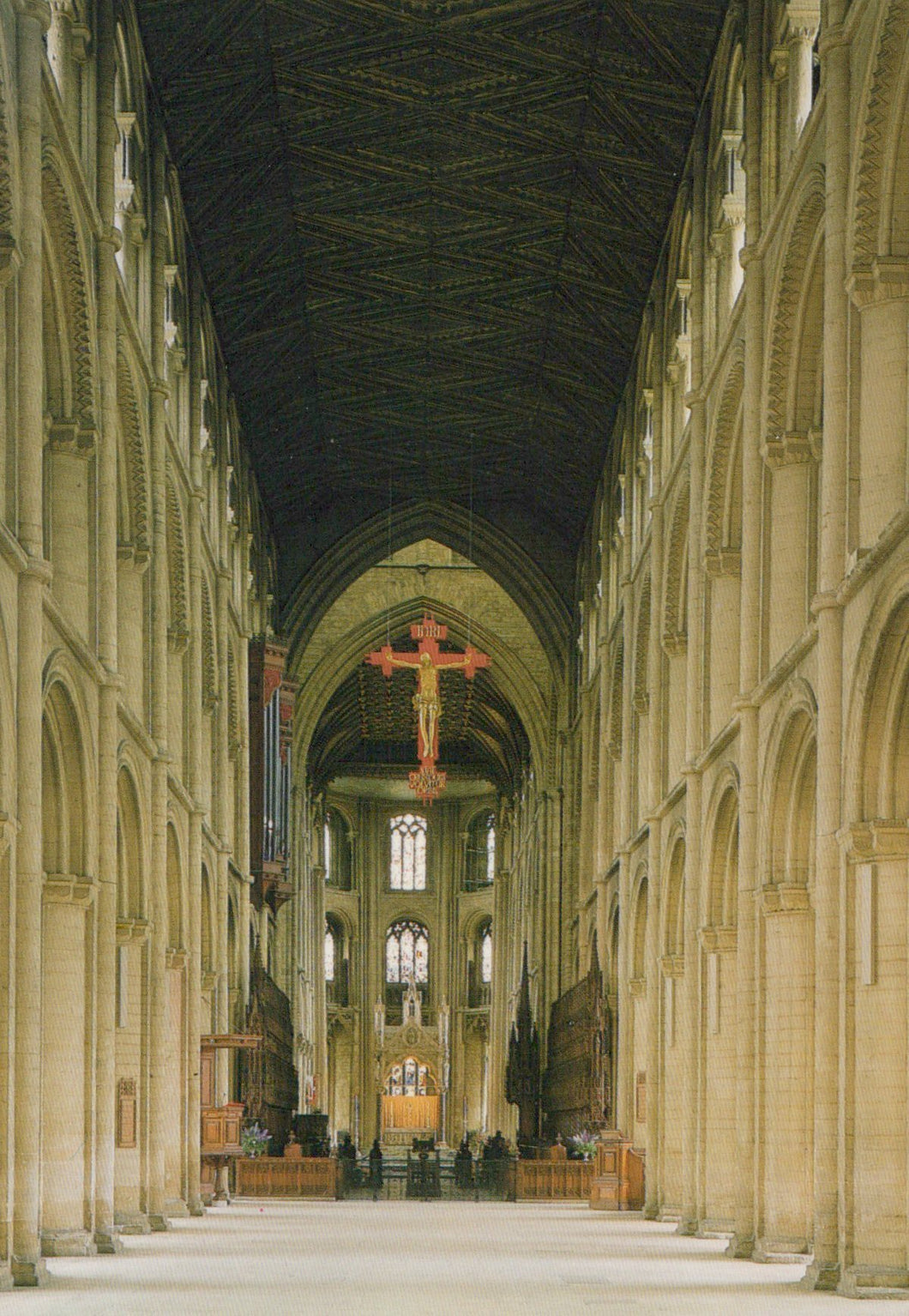 Nave of a large cathedral with high ceilings and stained glass windows.