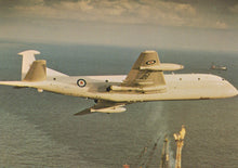 Load image into Gallery viewer, Military aircraft flying over water with a visible logo on the tail.
