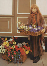 Load image into Gallery viewer, Child holding a basket of flowers in a room with floral decorations on the floor.
