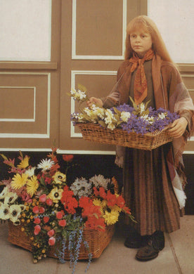 Child holding a basket of flowers in a room with floral decorations on the floor.