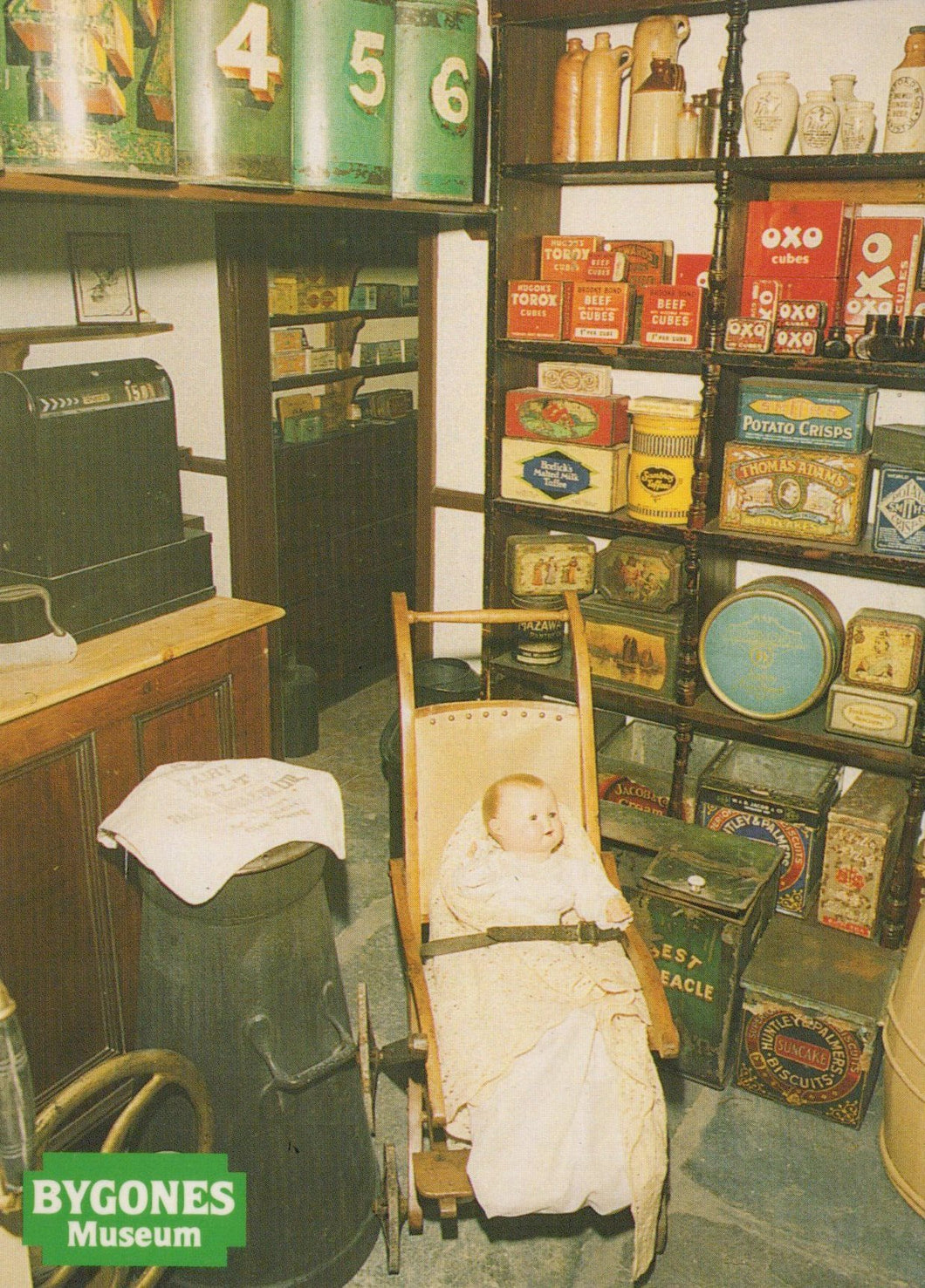 Vintage display with baby in pram and various historical products at Bygones Museum.