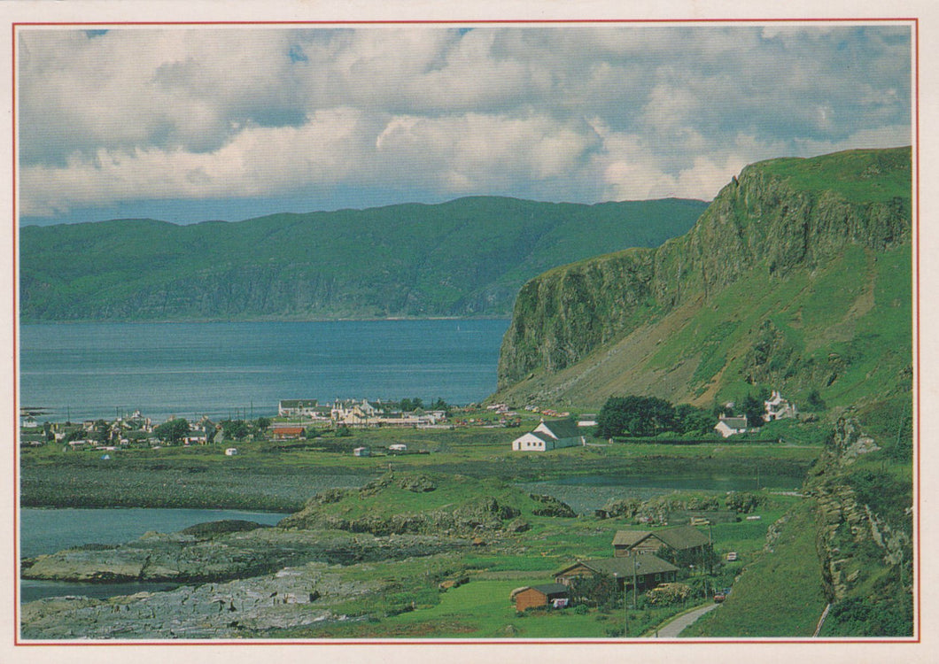 Scenic view of a coastal landscape with green hills and a body of water.
