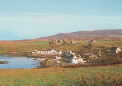 Scenic view of a village by a lake with mountains in the background