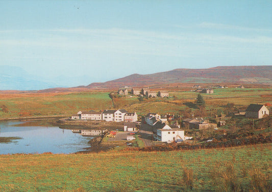 Scenic view of a village by a lake with mountains in the background