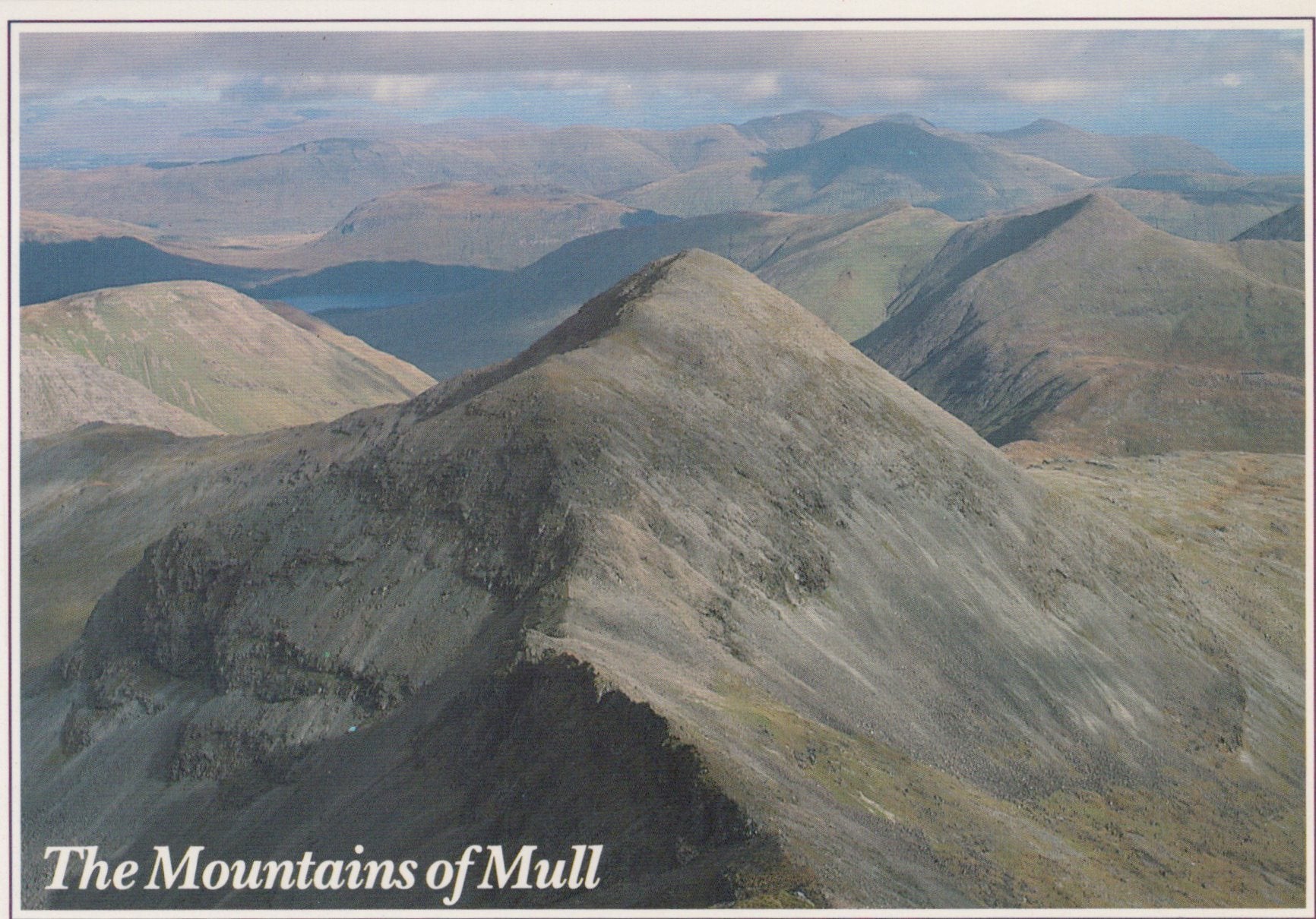 A scenic view of the Mountains of Mull with rolling hills and a cloudy sky.