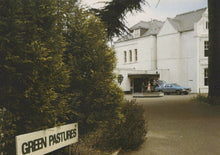 Load image into Gallery viewer, White building with &#39;Green Pastures&#39; sign in front, surrounded by trees.
