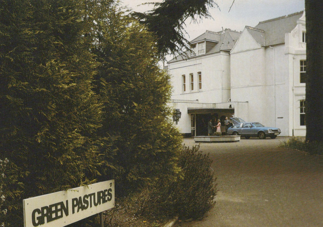 White building with 'Green Pastures' sign in front, surrounded by trees.