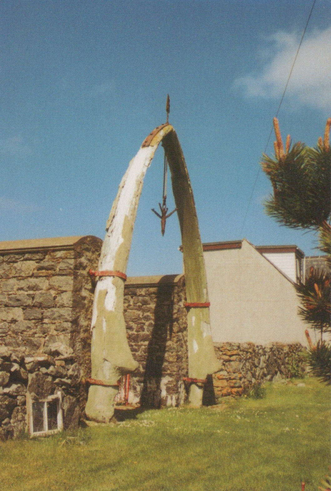 Large whalebone arch with a house and garden in the background