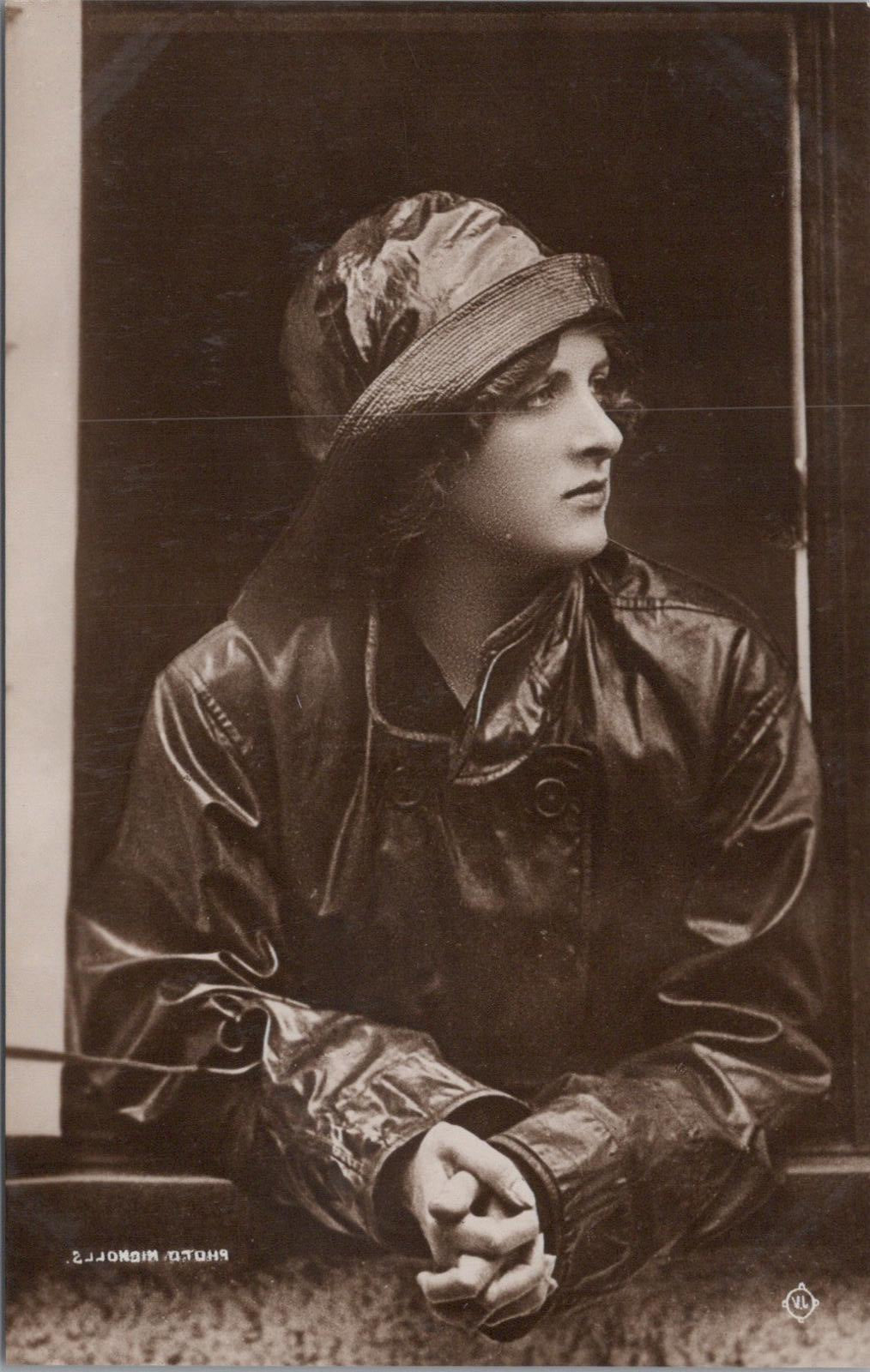 Person wearing a dark coat and hat in a sepia-toned photograph