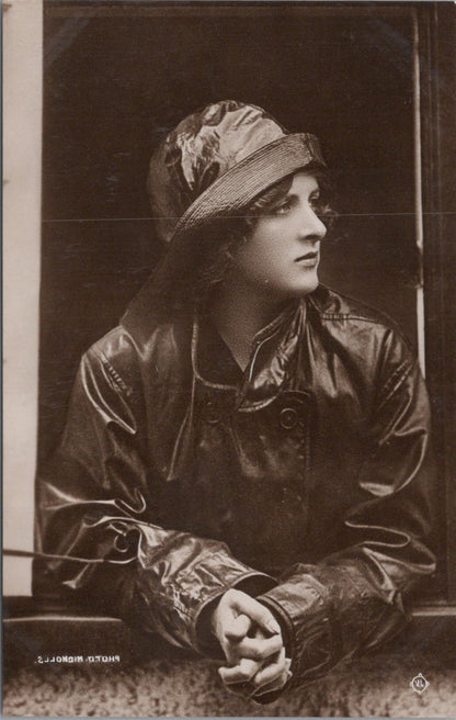 Person wearing a dark coat and hat in a sepia-toned photograph