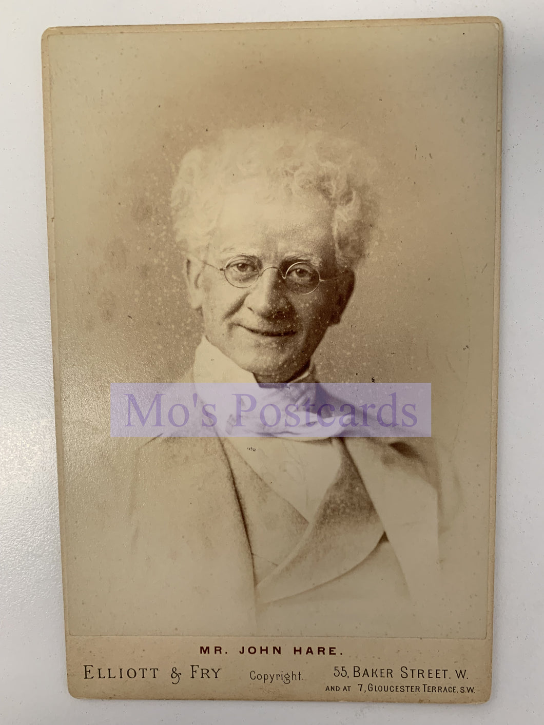 Vintage cabinet card of a man with white hair and glasses, featuring the text 'Mr. John Hare, Elliott & Fry'.